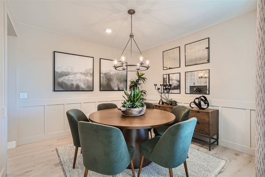 A dining room with a chandelier and chairs. A dining room with a chandelier and chairs.