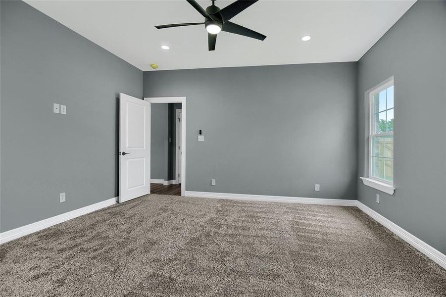 Carpeted empty room featuring ceiling fan