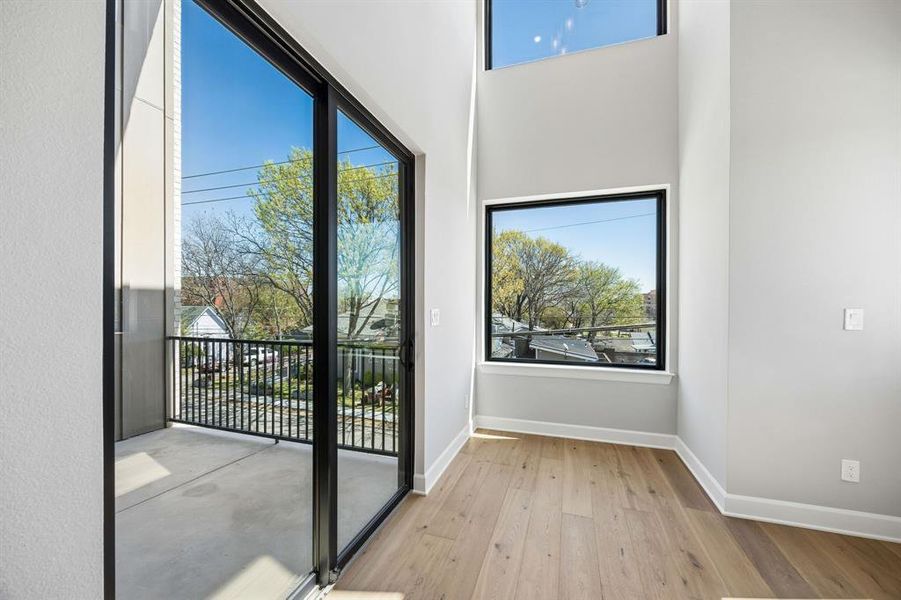 Doorway to outside with hardwood / wood-style floors and a high ceiling Doorway to outside with hardwood / wood-style floors and a high ceiling