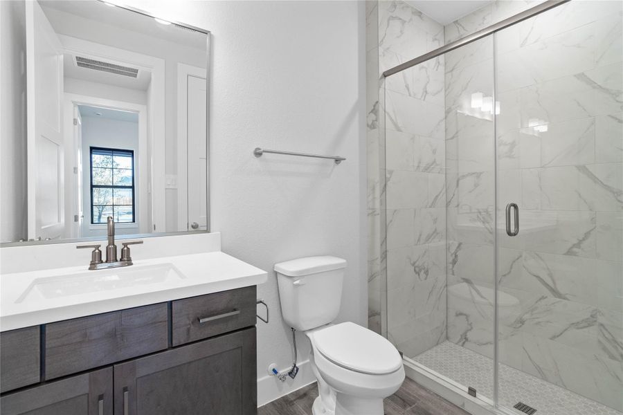 This well appointed secondary bathroom features stained cabinetry, white quartz countertop, walk-in shower with tile surround and sleek brushed nickel hardware. This well appointed secondary bathroom features stained cabinetry, white quartz countertop, walk-in shower with tile surround and sleek brushed nickel hardware.