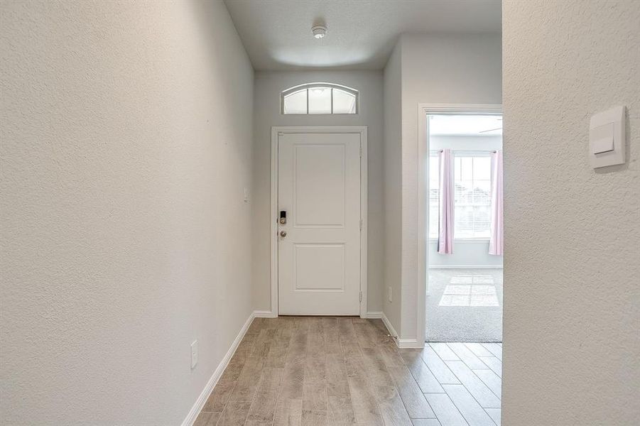 Entryway featuring a textured wall and light wood-style flooring