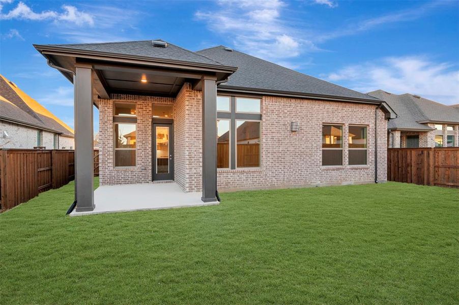 Back of property featuring a fenced backyard, a patio, brick siding, and a shingled roof