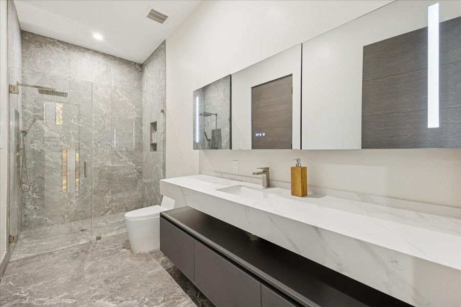 All bathrooms offer quartz countertops, multi-function shower systems, smart toilets and powered lighted vanity mirrors.
