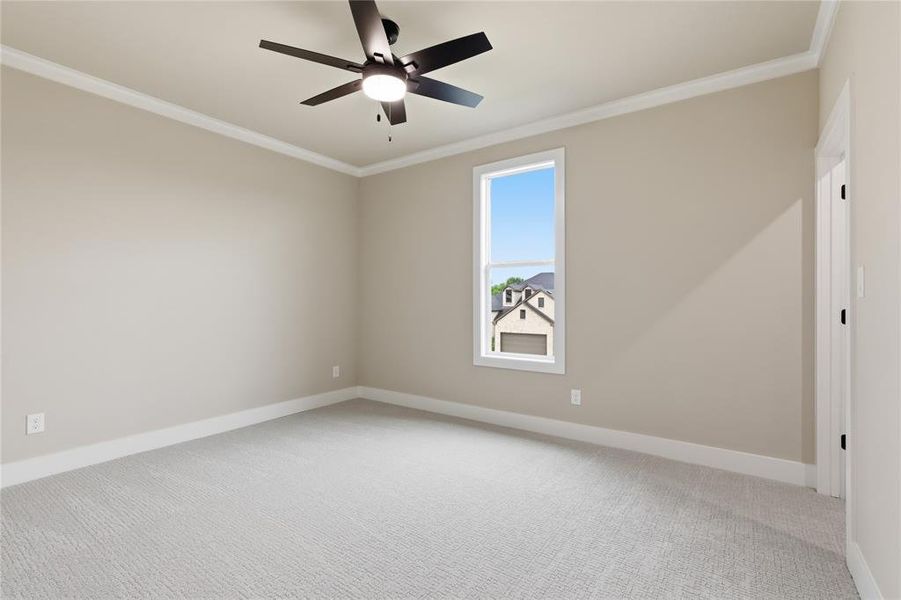 Carpeted interior room featuring neutral wall tones, white trim, and a ceiling fan with integrated lighting Carpeted interior room featuring neutral wall tones, white trim, and a ceiling fan with integrated lighting