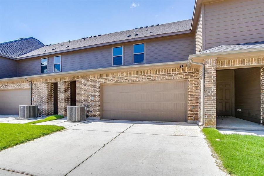 View of front of home with concrete driveway, brick siding, a garage, and roof with shingles View of front of home with concrete driveway, brick siding, a garage, and roof with shingles