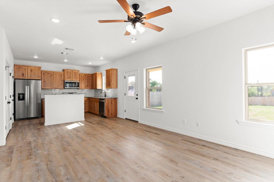 Kitchen with tasteful backsplash, a ceiling fan, light countertops, a sink, and stainless steel appliances Kitchen with tasteful backsplash, a ceiling fan, light countertops, a sink, and stainless steel appliances