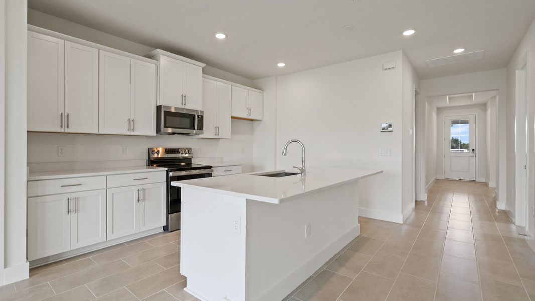 Kitchen and Island in the Buttonwood Floor Plan by DRB Homes in Ardisia Park in New Smyrna Beach