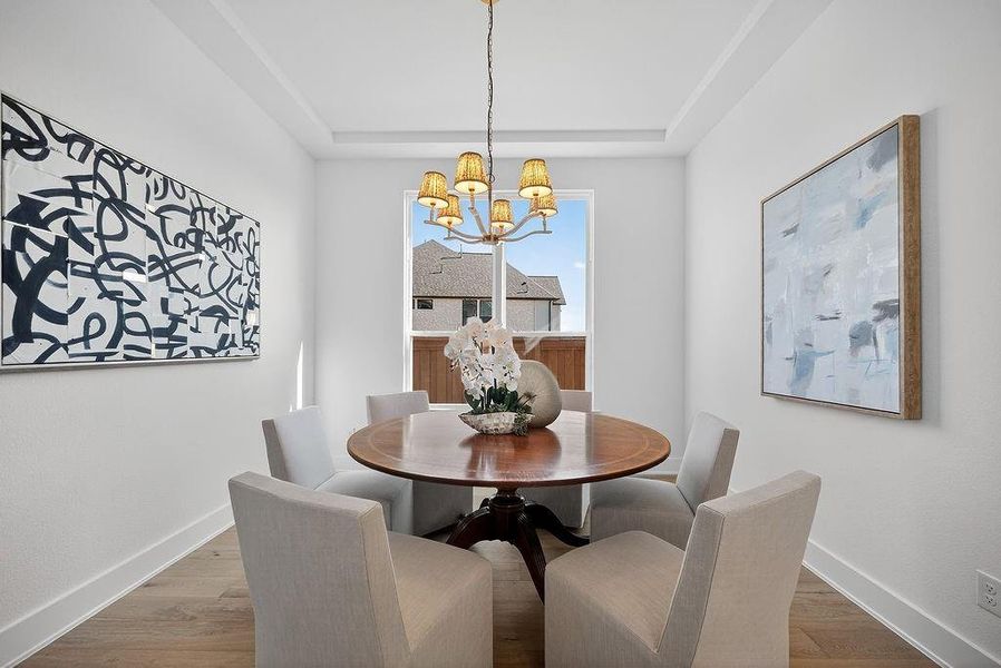 Dining room with wood finished floors and a chandelier Dining room with wood finished floors and a chandelier