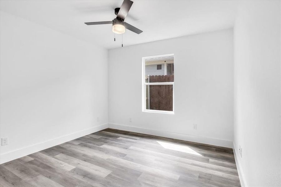 Unfurnished room with ceiling fan and light wood-type flooring