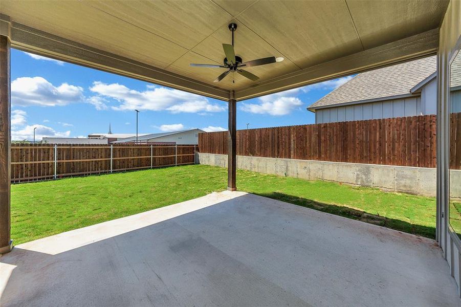 Fenced backyard featuring a patio and ceiling fan
