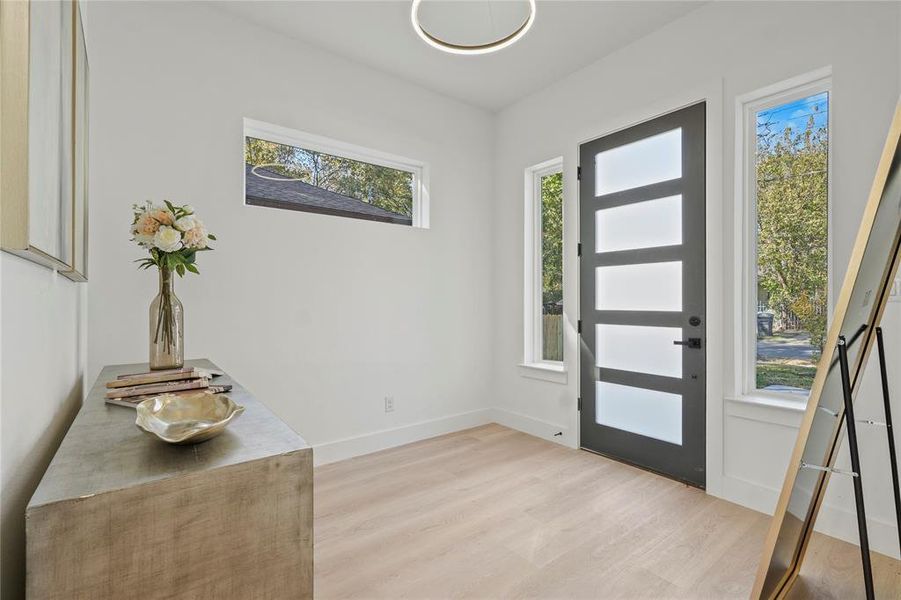 Foyer entrance with light wood finished floors and baseboards