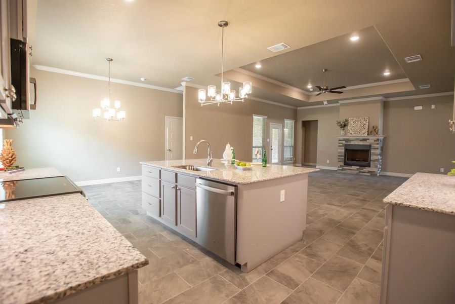 Kitchen with a sink, crown molding, stainless steel dishwasher, and ceiling fan with notable chandelier