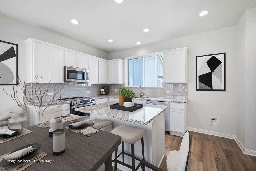 Granite countertops and clean white cabinetry anchor this modern culinary space. Granite countertops and clean white cabinetry anchor this modern culinary space.