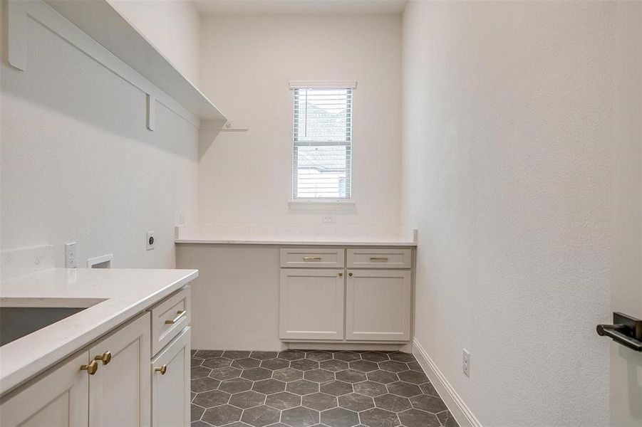 Laundry room featuring cabinets, washer hookup, electric dryer hookup, tile floor, and sink.