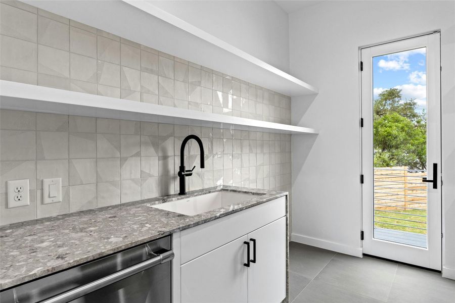 Butler's pantry/prep kitchen has a Thermador Emerald Dishwasher. Cabinets are Ventura Whitel Counter is Fior Di Bosco Marble by Santamargherita.