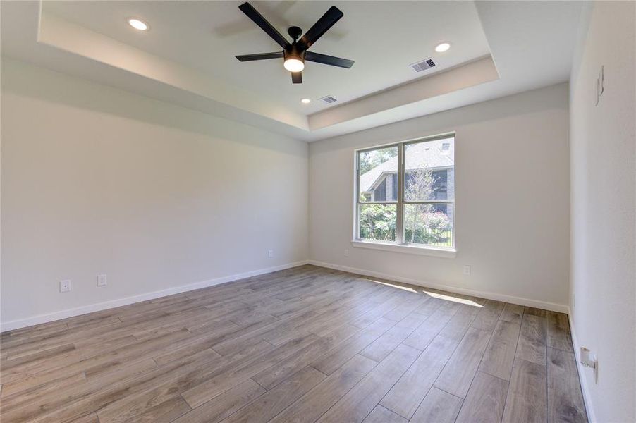 Master bedroom is framed by tray ceilings and plenty of natural light.