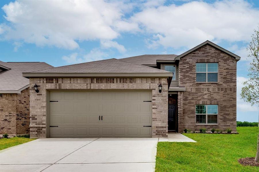 View of front of house featuring a garage and a front yard