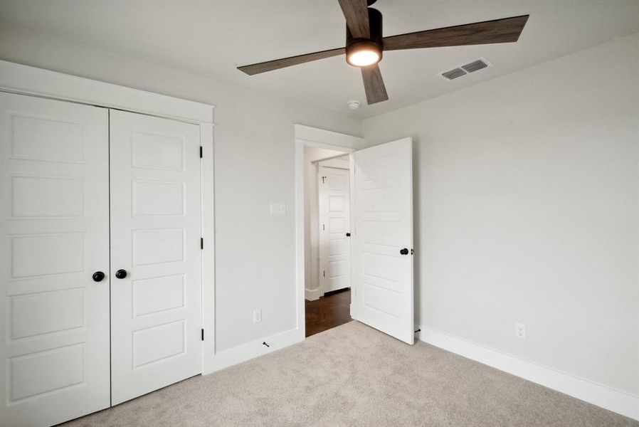 Unfurnished bedroom featuring a closet, carpet, and ceiling fan