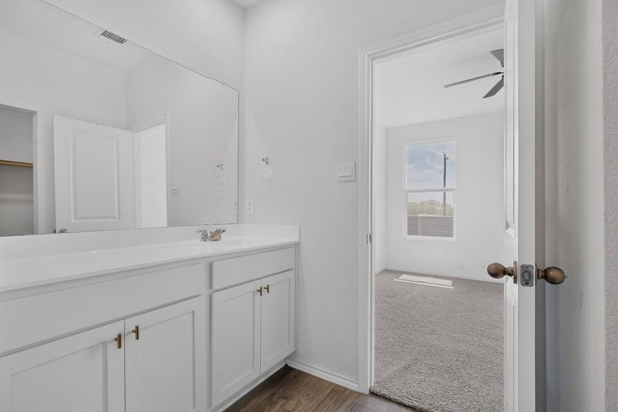 Clean lines and a spacious vanity define this modern bathroom connecting to a carpeted bedroom. Clean lines and a spacious vanity define this modern bathroom connecting to a carpeted bedroom.
