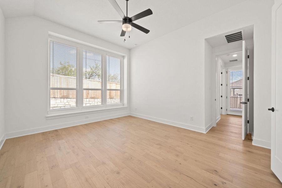 Spare room featuring light wood-style flooring, ceiling fan, and vaulted ceiling