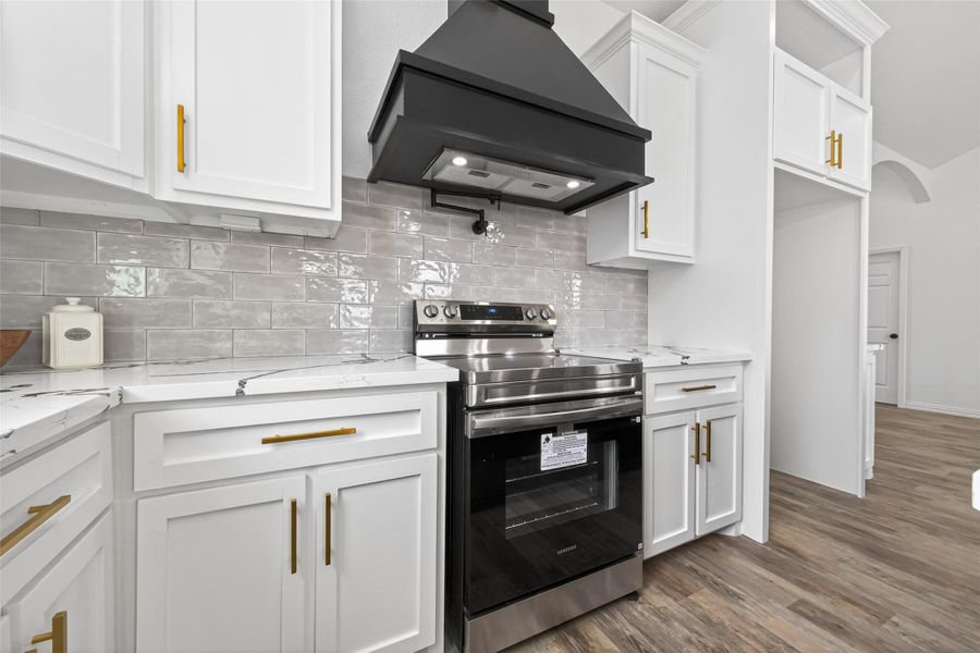 Modern kitchen featuring custom cabinetry, farmhouse sink, and large center island.