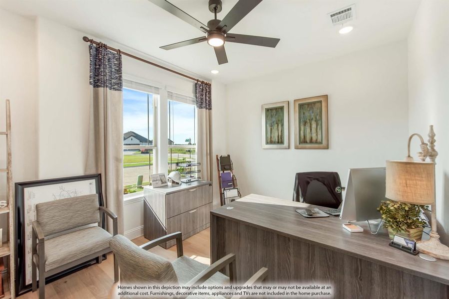 Home office with wood desk, ceiling fan, accent chair, and window with natural light Home office with wood desk, ceiling fan, accent chair, and window with natural light