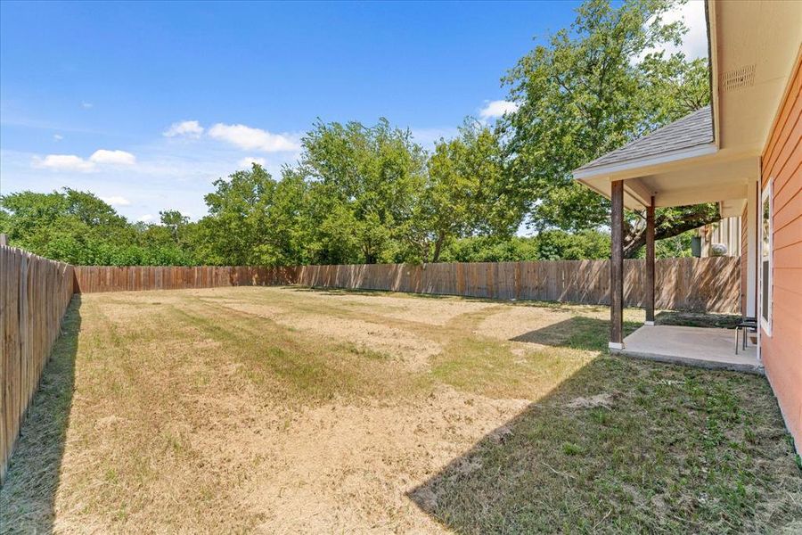 Fenced backyard with a patio