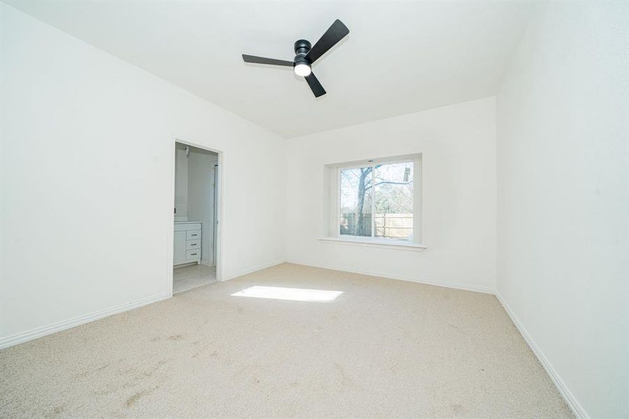Primary bedroom with carpet floors and ceiling fan