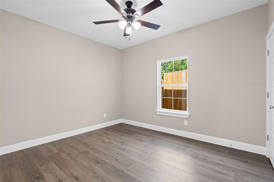 Empty room featuring wood finished floors and a ceiling fan Empty room featuring wood finished floors and a ceiling fan