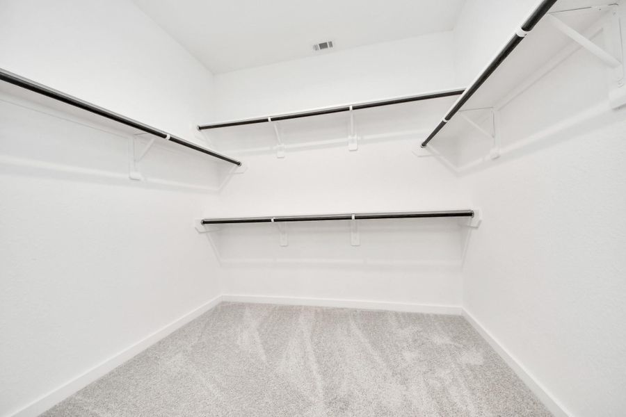 Walk-in closet that epitomizes luxury and practicality. This generously sized space features built-in shelving, offering abundant room for impeccable organization. High ceilings and recessed lighting create a bright and welcoming ambiance.