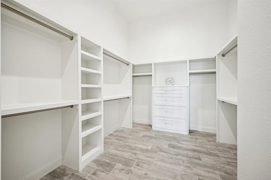 Primary bedroom walk-in-closet with built-ins, abundant hanging space, and room to grow vertically.