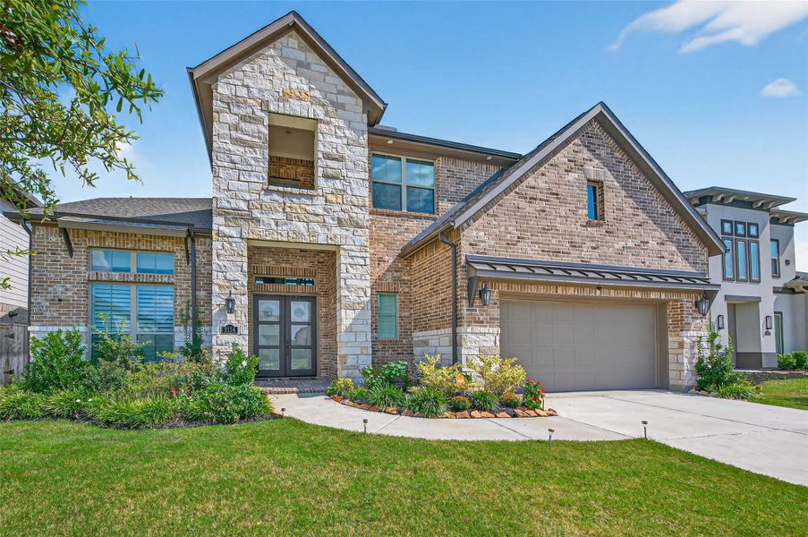This is a modern two-story home with a mix of brick and stone exterior. It features a double garage, a well-maintained front yard, and a welcoming covered entrance. The design is contemporary with clean lines and large windows, enhancing curb appeal. This is a modern two-story home with a mix of brick and stone exterior. It features a double garage, a well-maintained front yard, and a welcoming covered entrance. The design is contemporary with clean lines and large windows, enhancing curb appeal.