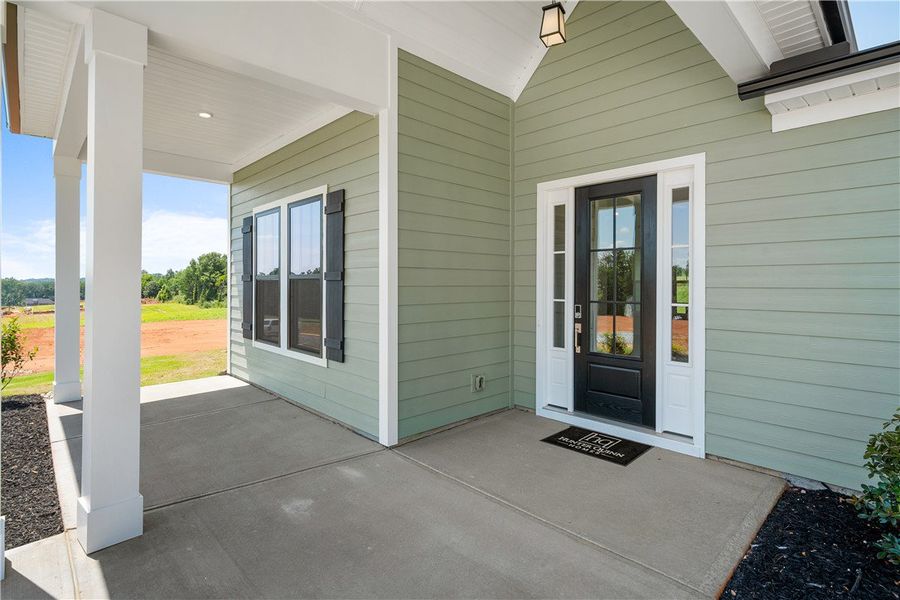 A welcoming front porch with sturdy pillars provid A welcoming front porch with sturdy pillars provid