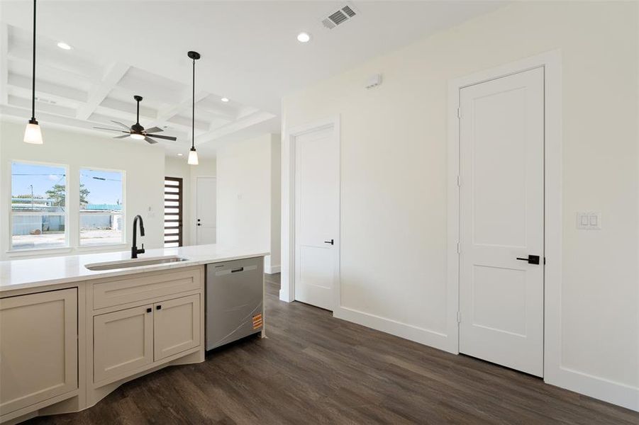Kitchen featuring coffered ceiling, pendant lighting, beam ceiling, dishwasher, and dark wood-style flooring Kitchen featuring coffered ceiling, pendant lighting, beam ceiling, dishwasher, and dark wood-style flooring