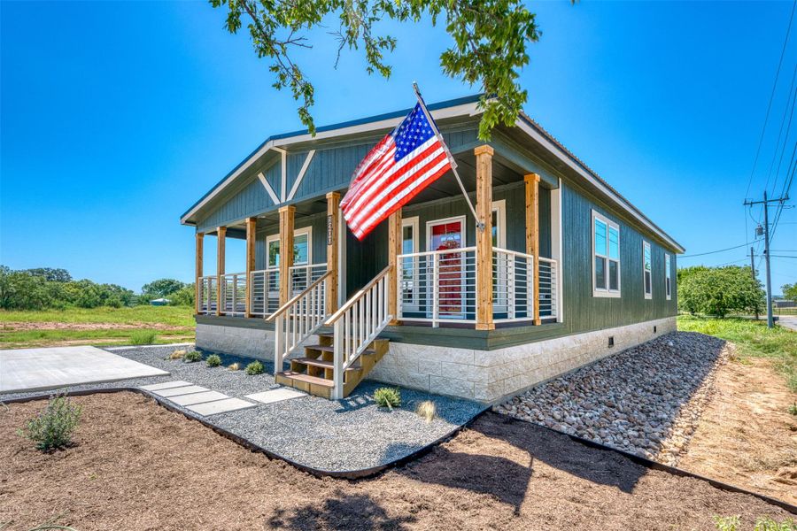 A charming porch entrance with a striking red door welcomes you to this verdant countryside dwelling. A charming porch entrance with a striking red door welcomes you to this verdant countryside dwelling.