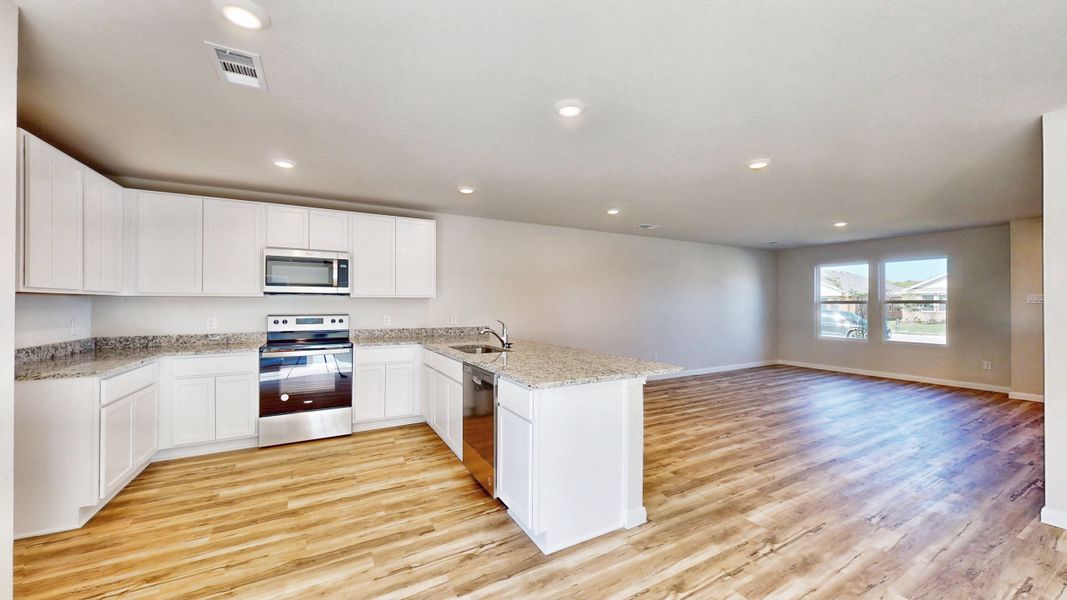 A kitchen with white cabinets.