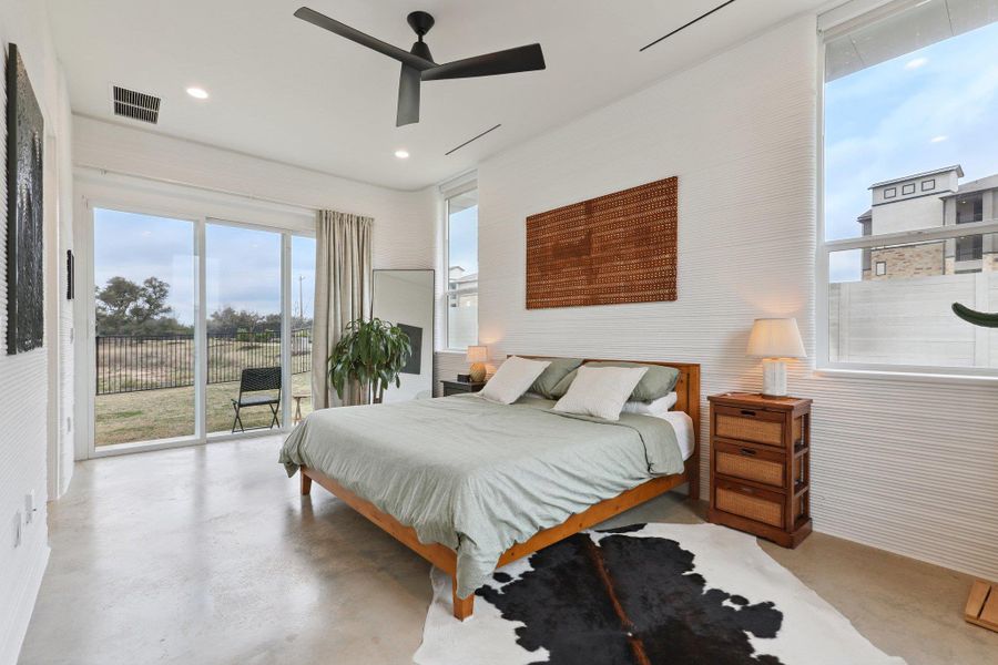 Bedroom featuring concrete floors, access to outside, and ceiling fan