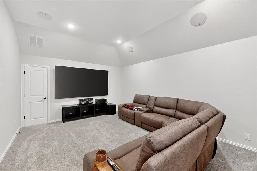 Carpeted living area with lofted ceiling and recessed lighting Carpeted living area with lofted ceiling and recessed lighting