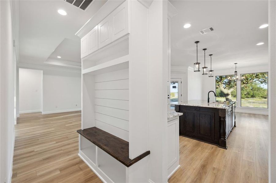 Hallway with plenty of natural light, a notable chandelier, and light hardwood / wood-style floors