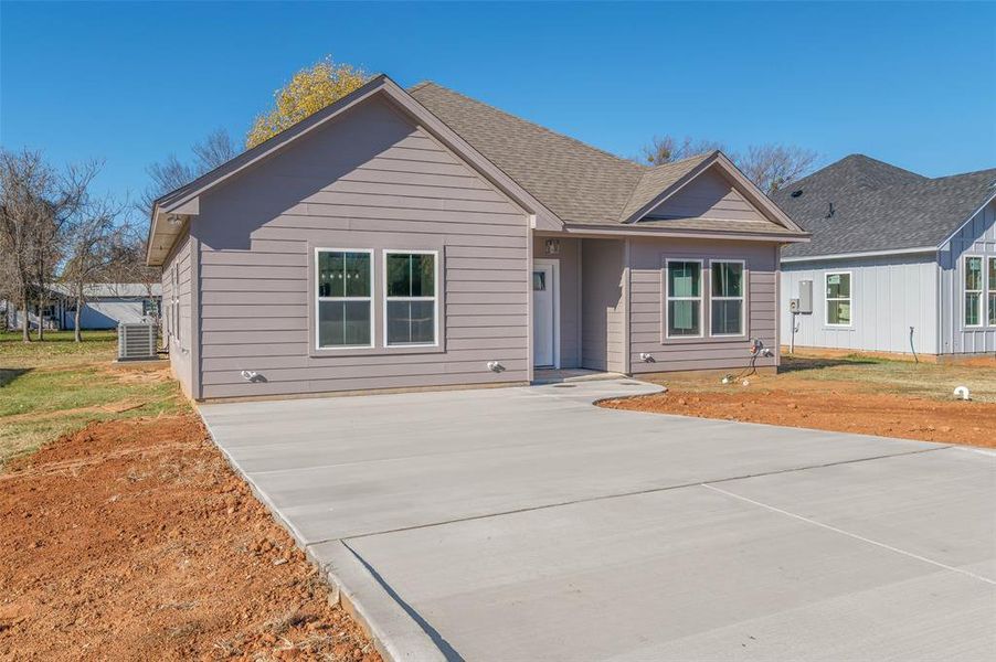 View of front facade featuring cooling unit and a front yard View of front facade featuring cooling unit and a front yard