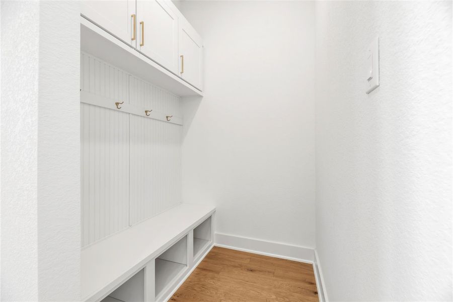 Enhancing everyday organization, this built-in mudroom area features custom cabinetry, ample hooks, and thoughtful storage to keep the home pristine.