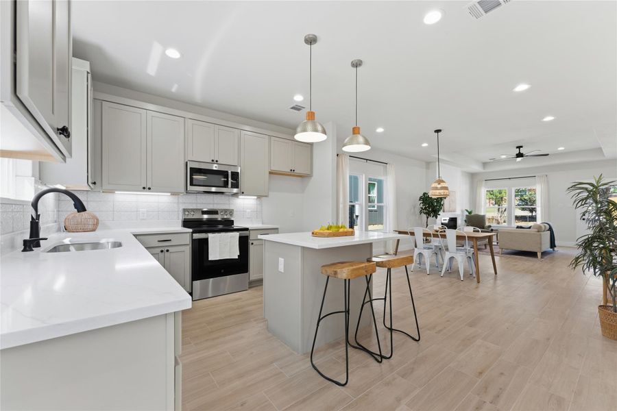 Warm oat-colored cabinetry, marble-look stone countertops, and a beautiful window above the sink overlooking the deck, backyard, and greenspace beyond. Open and bright with generous cabinet storage,a large pantry,plus an island for enjoying friends and family while you cook.
