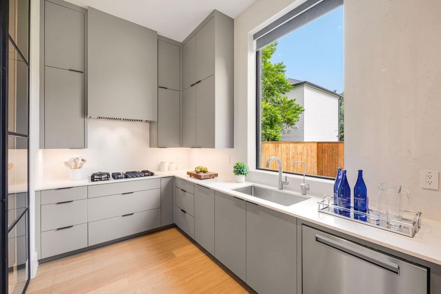 [PREP KITCHEN] The thoughtfully designed prep kitchen is seamlessly connected to the main kitchen through an elegant glass door and features a second dishwasher, gas cooktop, secondary refrigerator, generous storage, and extensive workspace for ultimate convenience.