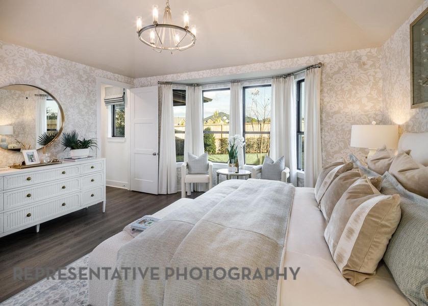 Bedroom with wallpapered walls, dark wood-style flooring, vaulted ceiling, and a chandelier Bedroom with wallpapered walls, dark wood-style flooring, vaulted ceiling, and a chandelier