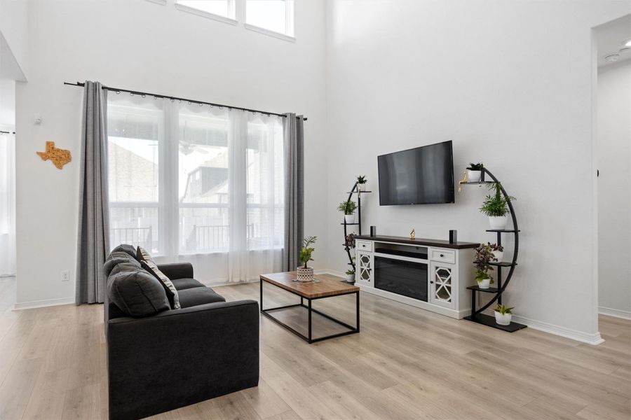 Living area featuring a towering ceiling and light wood-style floors Living area featuring a towering ceiling and light wood-style floors