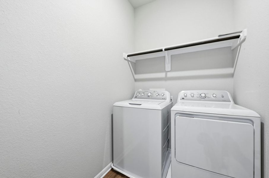 Dedicated laundry area featuring a white top-load washing machine and front-load dryer Dedicated laundry area featuring a white top-load washing machine and front-load dryer