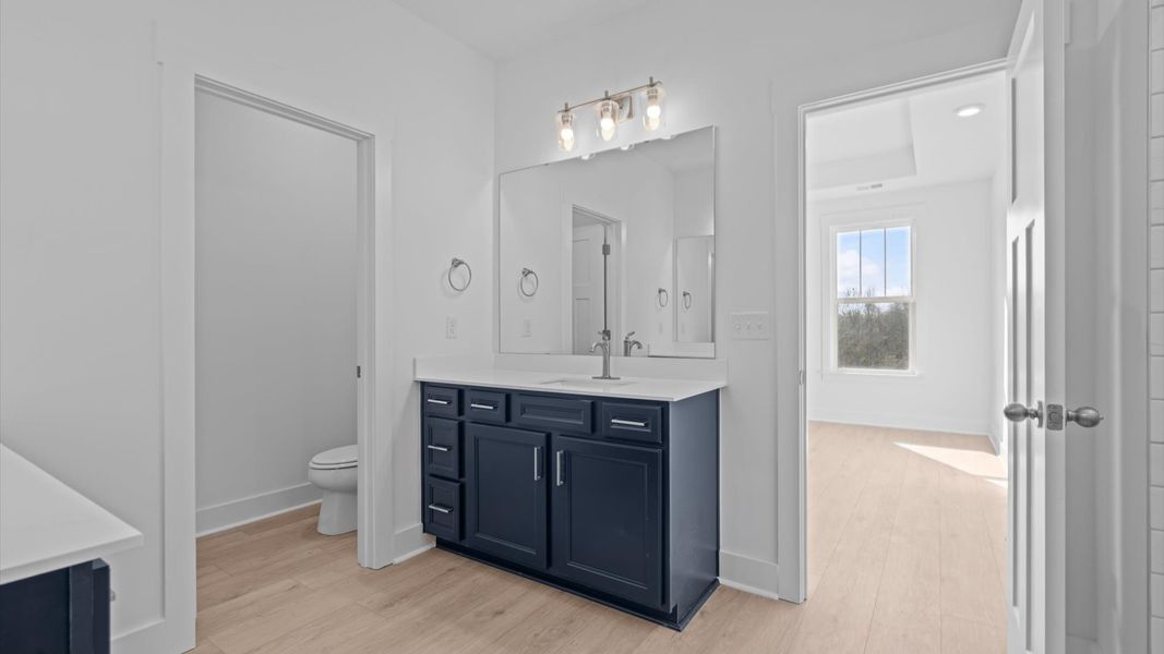First-rate primary bathroom offering an elegant tiled walk-in shower and separate sinks with superior style