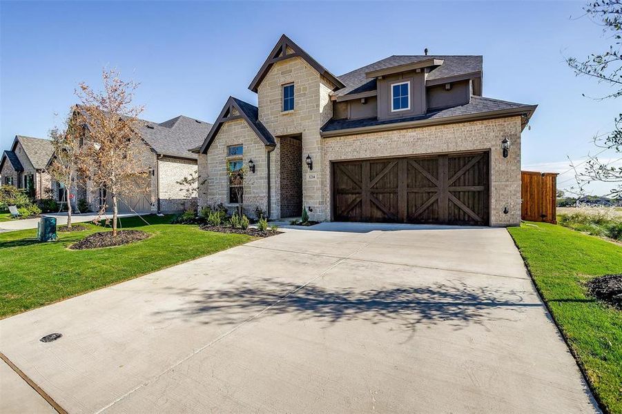 View of front of home with a front yard and a garage