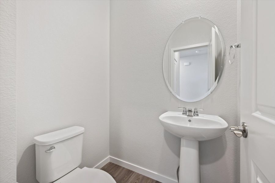 A bathroom with a round mirror.