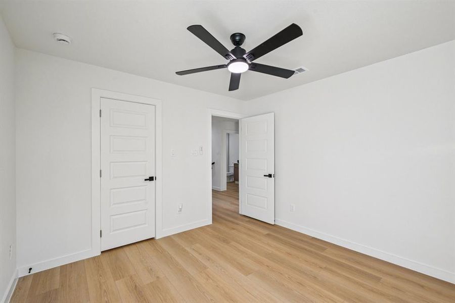 Unfurnished bedroom with light wood-style floors and ceiling fan